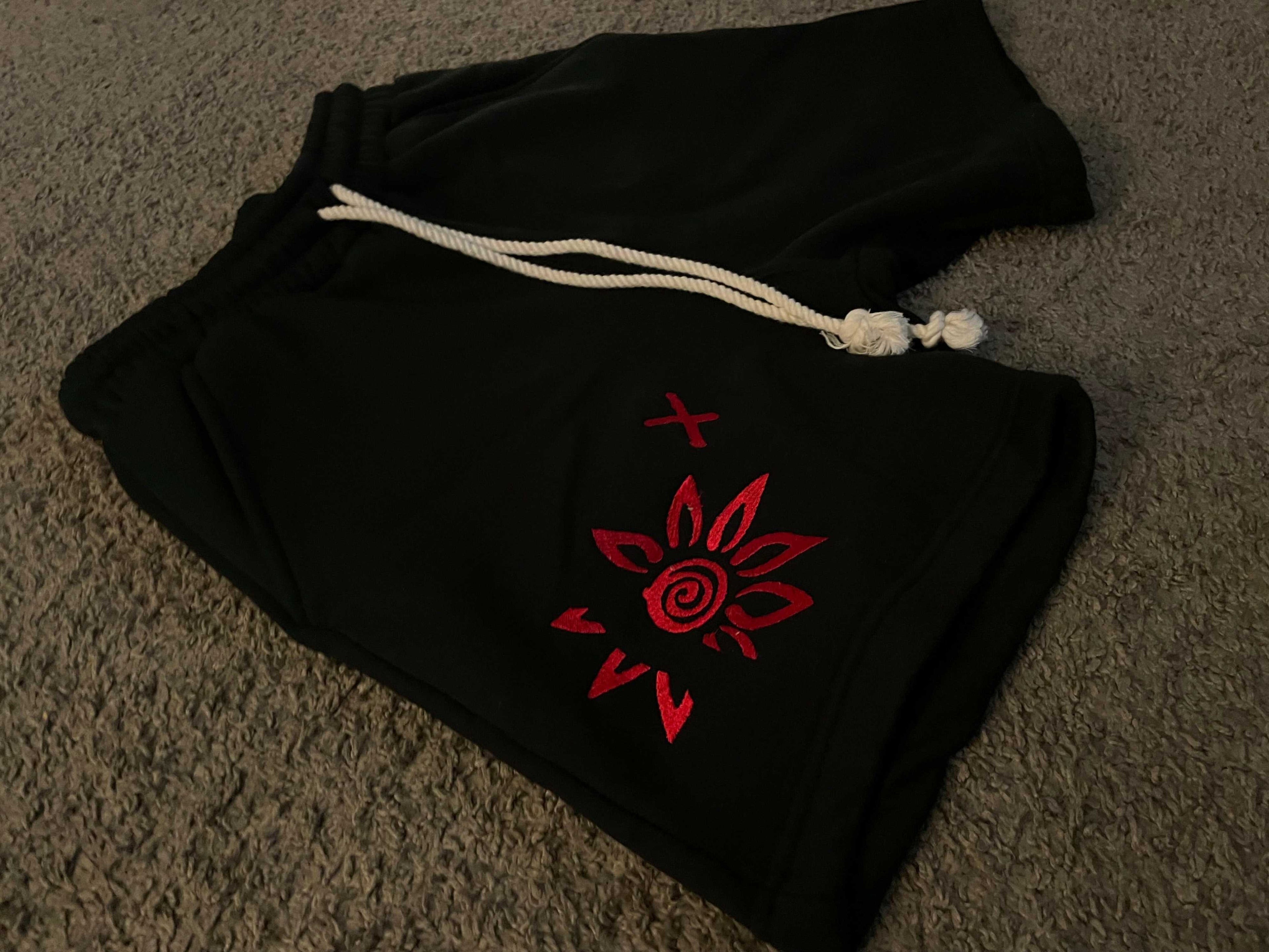 Black shorts with red embroidered WISE Flower x design and white drawstring