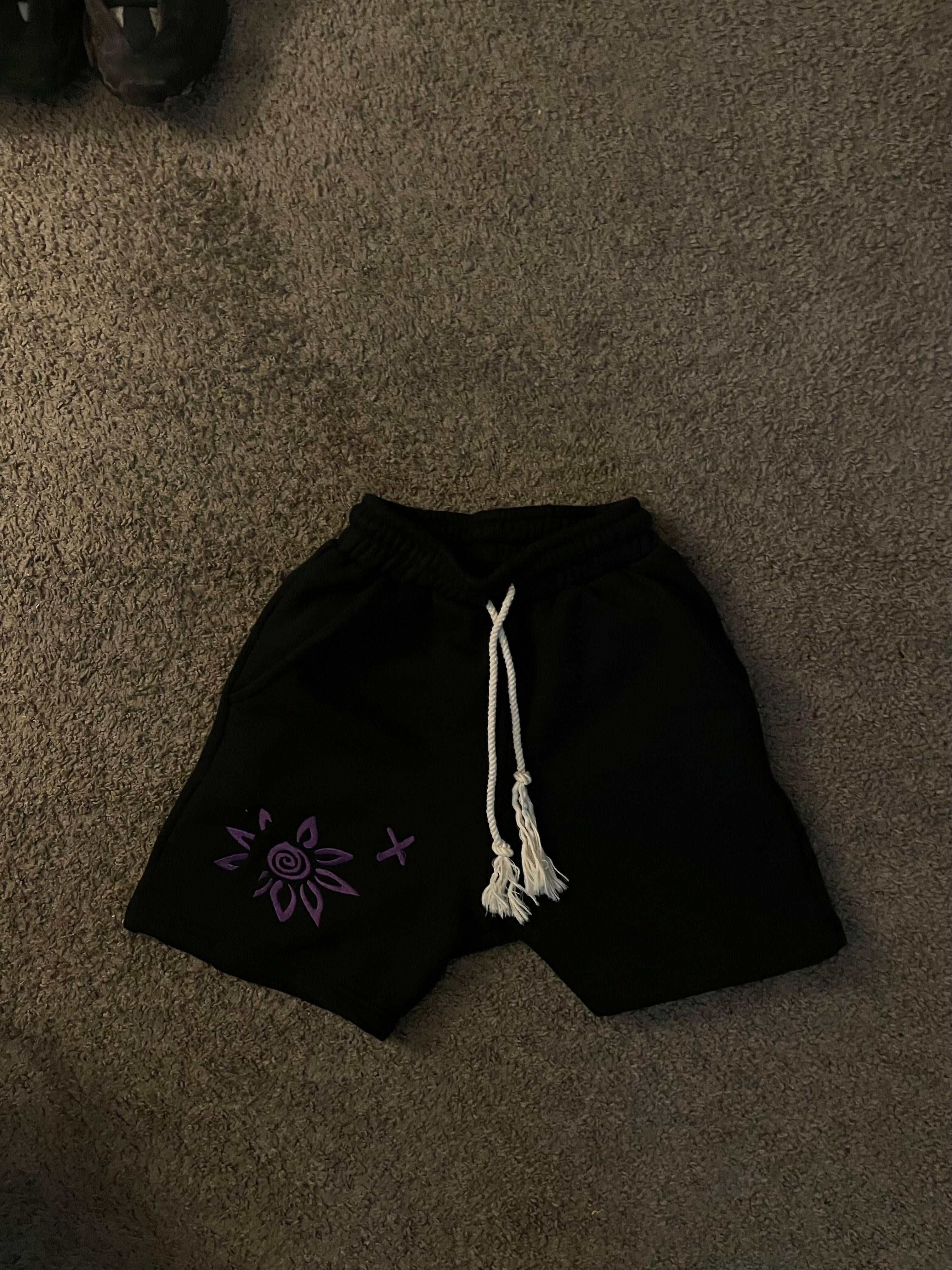 Black shorts with purple embroidered Wise Flower X design and white drawstring