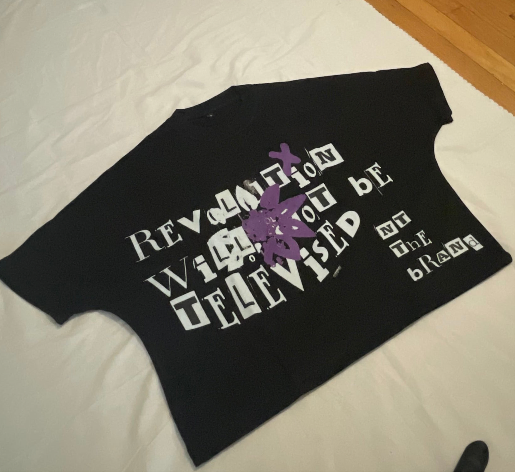Black RWNBT Box T-shirt with front purple flower X symbol and white mixed font text design