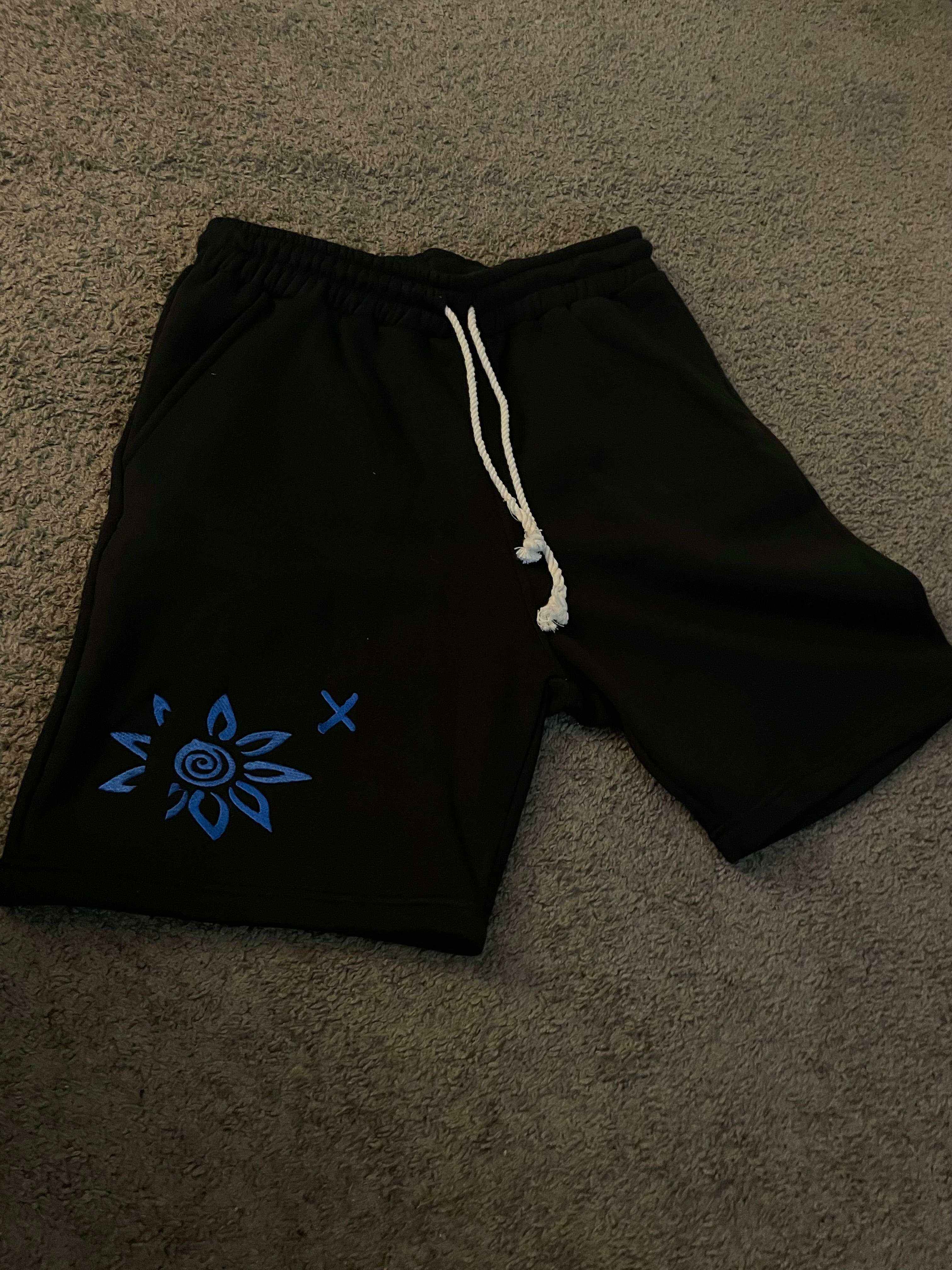 Black shorts with blue embroidered WISE FLOWER X design and white drawstring rope