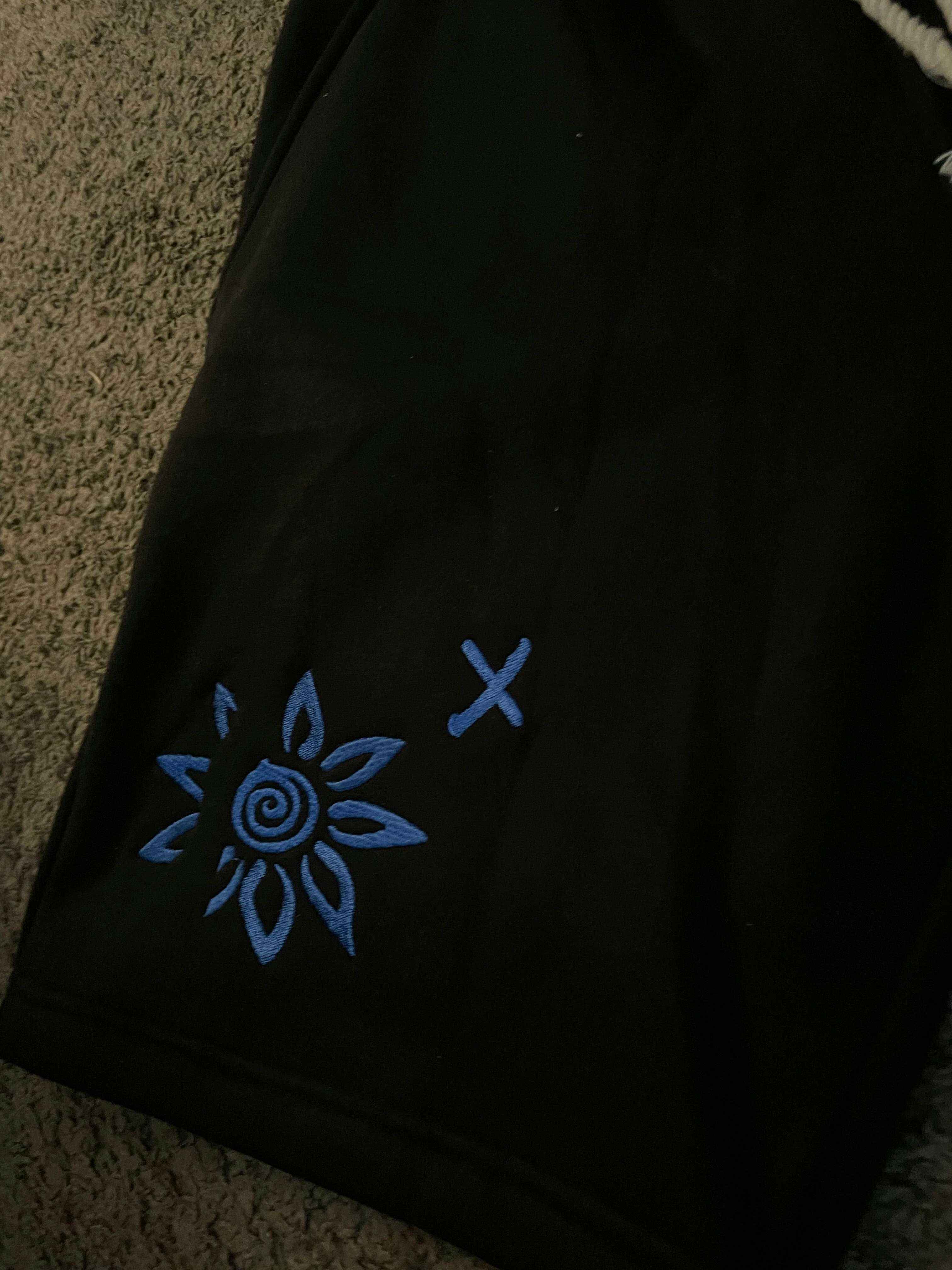 Black shorts with blue embroidered WISE FLOWER X design and beach rope drawstring